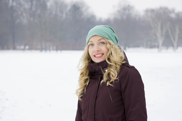 Mujer caminando en el campo cubierto de nieve — Foto de Stock