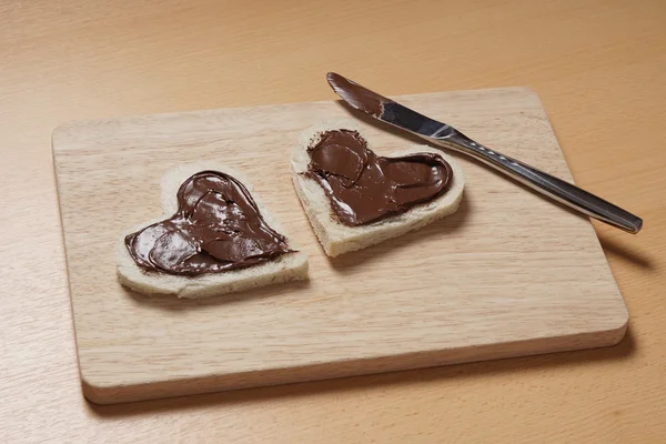 Fatias de torradas em forma de coração com propagação de chocolate — Fotografia de Stock