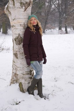 Kışın ağaç karşı yaslanmış kadın