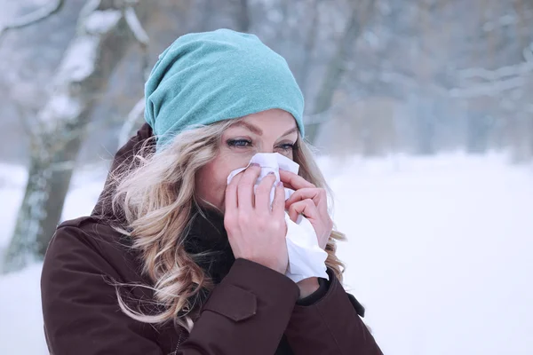 여자 겨울에 그녀의 코를 불고 — 스톡 사진
