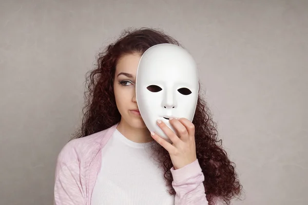 Triste fille se cachant derrière masque — Photo