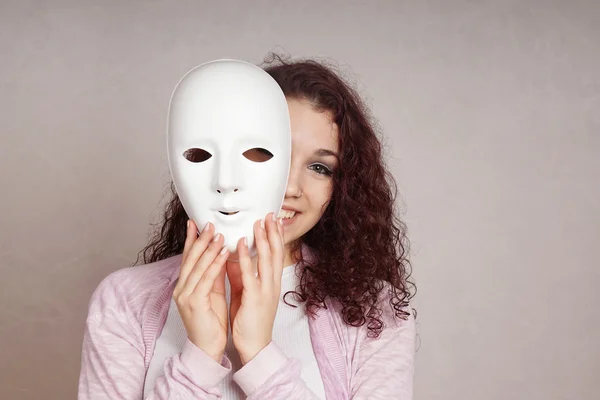 Menina feliz espreitando atrás da máscara — Fotografia de Stock