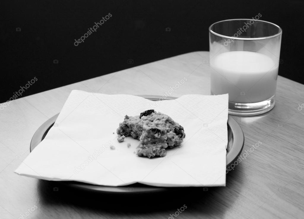 Half-eaten cookie with a half drunk glass of milk
