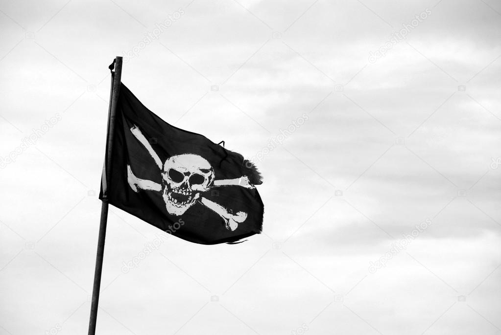 Torn Jolly Roger flies from flagpole