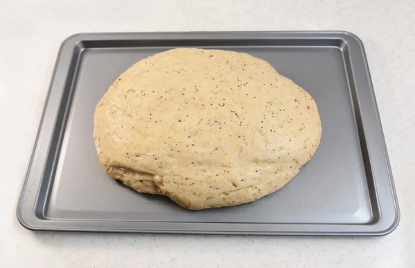 复活的面包面团在烤盘上 — 图库照片