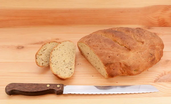 Bread knife with slices of bread cut from a loaf — Stock Photo, Image