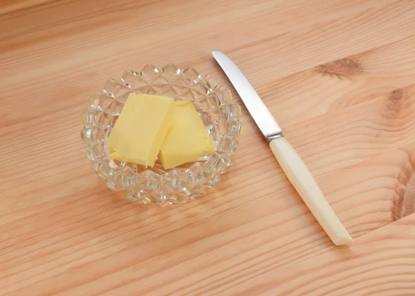 Mantequilla en un plato de vidrio con un cuchillo pequeño para untar —  Fotos de Stock