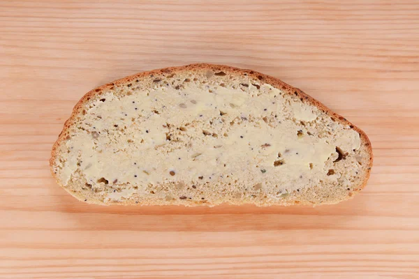 Slice of buttered bread on a wooden table — Stock Photo, Image