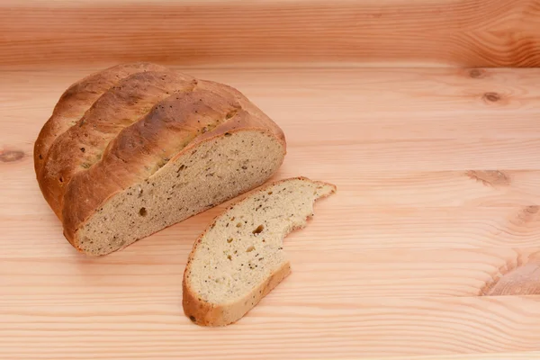 Half-gegeten brood op een tafel met een gesneden schijfje — Stockfoto