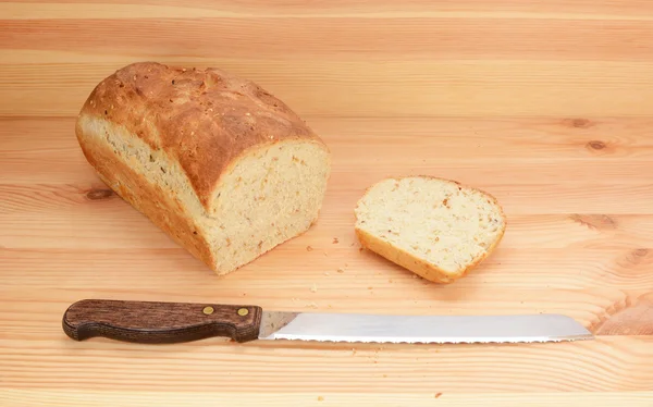 Хлебный нож со свеженарезанным буханкой хлеба — стоковое фото