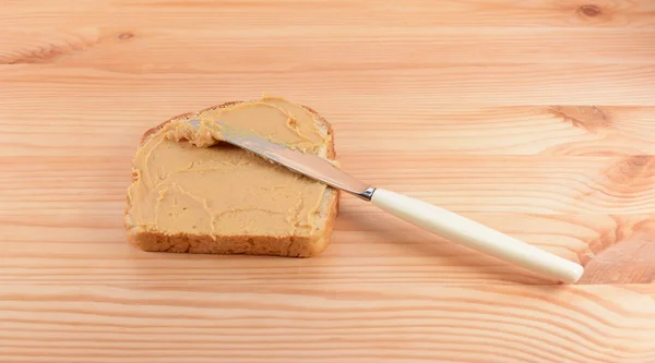 Esparcir mantequilla de maní en una rebanada de pan —  Fotos de Stock
