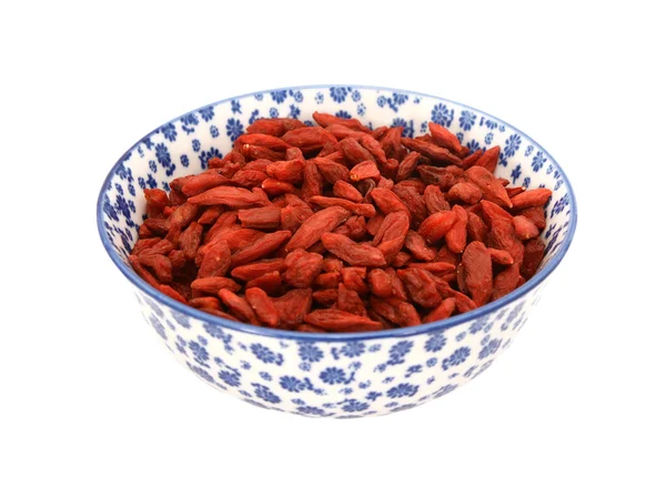 Красные ягоды годжи в сине-белой чаше фарфора — стоковое фото