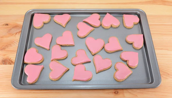 Array of heart-shaped cookies with pink frosting — Stock Photo, Image
