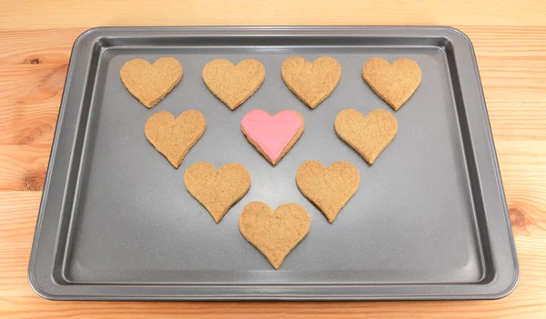 Heart-shaped biscuits on a cookie sheet — Stock Photo, Image