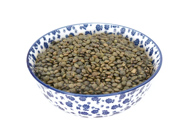 Marbled dark green lentils in a blue and white china bowl — Stock Photo, Image