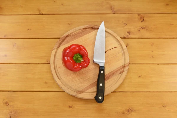 Poivron rouge avec un couteau sur une planche à découper — Photo