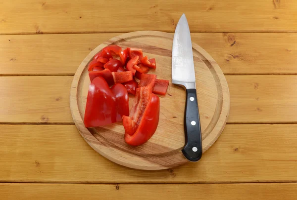 Pimienta roja rebanada con cuchillo en una tabla de cortar —  Fotos de Stock