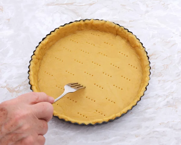 Woman finishes pricking holes in a pastry pie crust — Stock Photo, Image