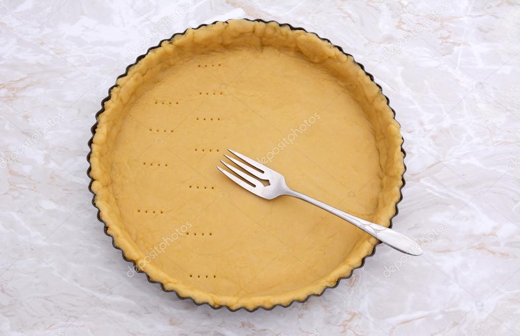 Pricking shortcrust pastry case with a metal fork