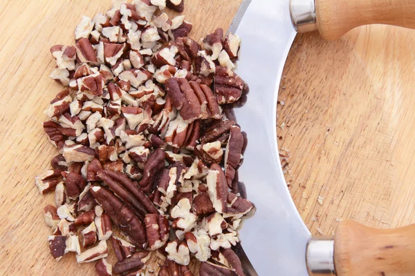 Chopped toasted pecans with a rocking knife — Stock Photo, Image