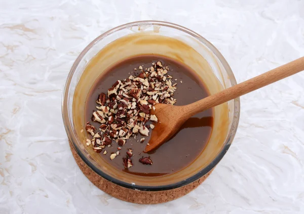 Stirring chopped pecan nuts into filling for pecan pie — Stock Photo, Image