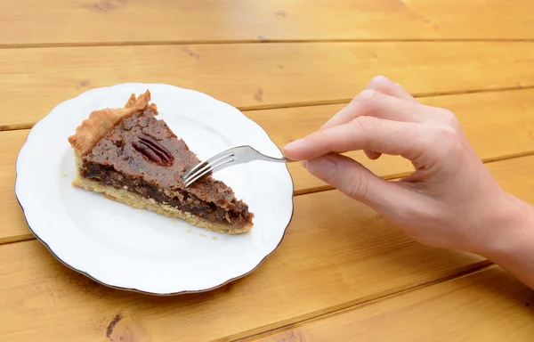 Frau schneidet in ein Stück Pekannuchen — Stockfoto