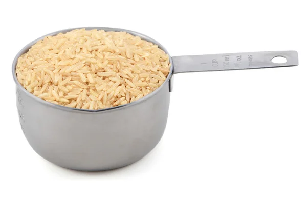 Длинный коричневый рис в мерной чашке — стоковое фото