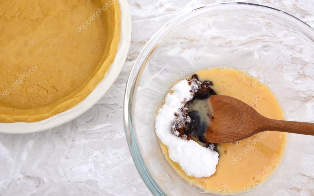 Stirring sugar into beaten egg for pumpkin pie filling