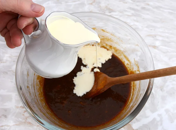 Pouring cream into pumpkin pie filling — Stock Photo, Image