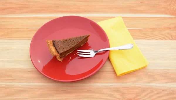 Rebanada de pastel de calabaza en un plato rojo — Foto de Stock