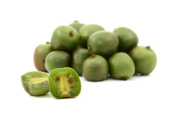 Kiwi berry sliced open in front of pile of berries Stock Picture