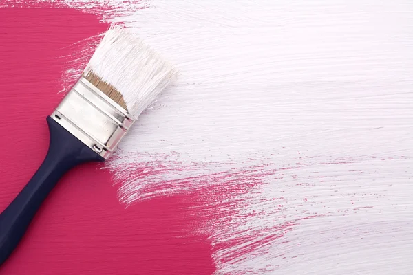 Peinture au pinceau avec peinture blanche sur rose — Photo