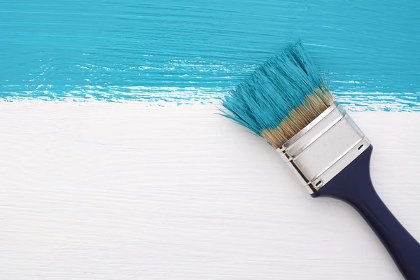 Bande de peinture turquoise avec un pinceau sur blanc — Photo