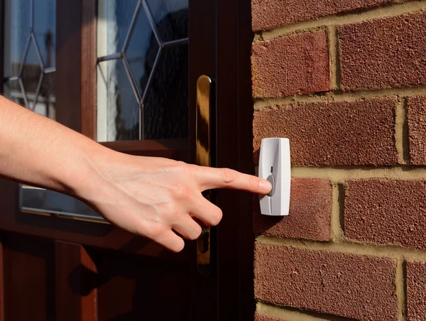 Woman extends her hand to ring doorbell — Stock Photo, Image