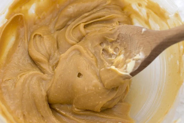 Peanut butter and butter with a wooden spoon — Stock Photo, Image