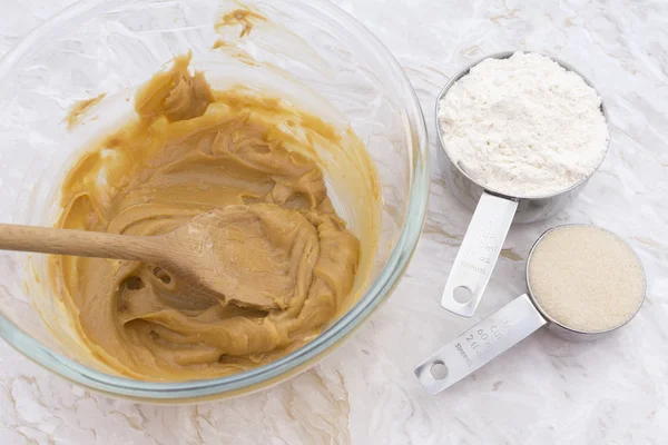 Cups of flour and sugar with peanut butter mixture — Stock Photo, Image