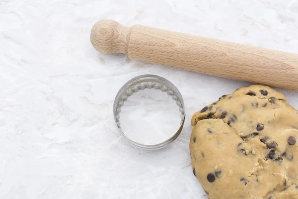 Chocolate chip cookie dough with rolling pin and cookie cutter — Stock Photo, Image