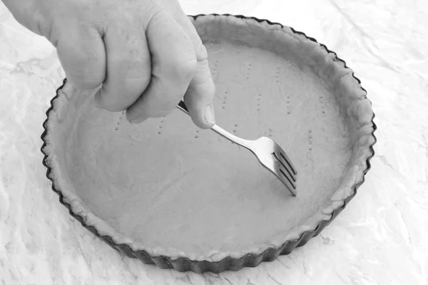 Mujer usando tenedor para perforar agujeros en una corteza de pastel sin cocer —  Fotos de Stock