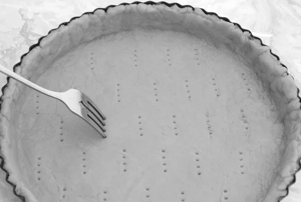Tenedor haciendo agujeros en una caja de pastelería cruda —  Fotos de Stock