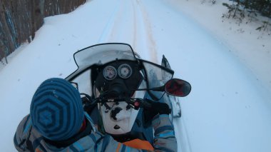 Kar araçları medeniyetten uzak bir kış ormanı yolunda seyahat ederler.