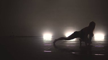 Modern kostümlü balerin sahnede şehvetle dans ediyor.