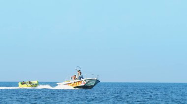 Halkidiki, Yunanistan - 25 Haziran 2018: Tropikal turkuaz körfezde aşırı süratli sürat teknesi su sporları küfürü