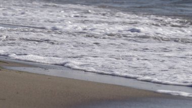 Tropikal kumsalın kumlarında deniz dalgaları. Yakın plan.
