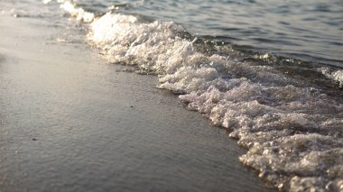 Baloncukları kapatın ve deniz dalgalarını sahile, arka plan döngüsünü