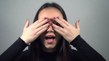 Utangaç, baştan çıkarıcı kız kameraya bakıp gülümsüyor.