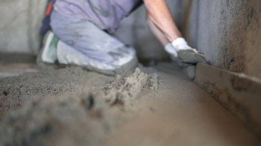 Bir inşaat işçisi çimento ve beton döküyor. Foreman yola yeni beton döktü.