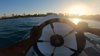 Mısır, Hurghada 'nın mavi denizinde sürat teknesinin dümenindeki kaptanın eli