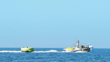 Halkidiki, Yunanistan - 25 Haziran 2018: Tropikal turkuaz körfezde aşırı süratli sürat teknesi su sporları küfürü