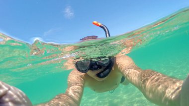 Su yüzeyinde yüzen adamın selfie 'si. Gopro kubbesi atışı