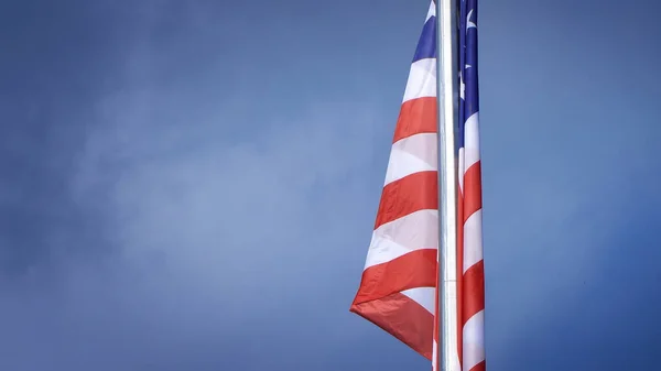 Zbliżenie Dużej Amerykańskiej Flagi Biegunie Błękitnego Nieba — Zdjęcie stockowe